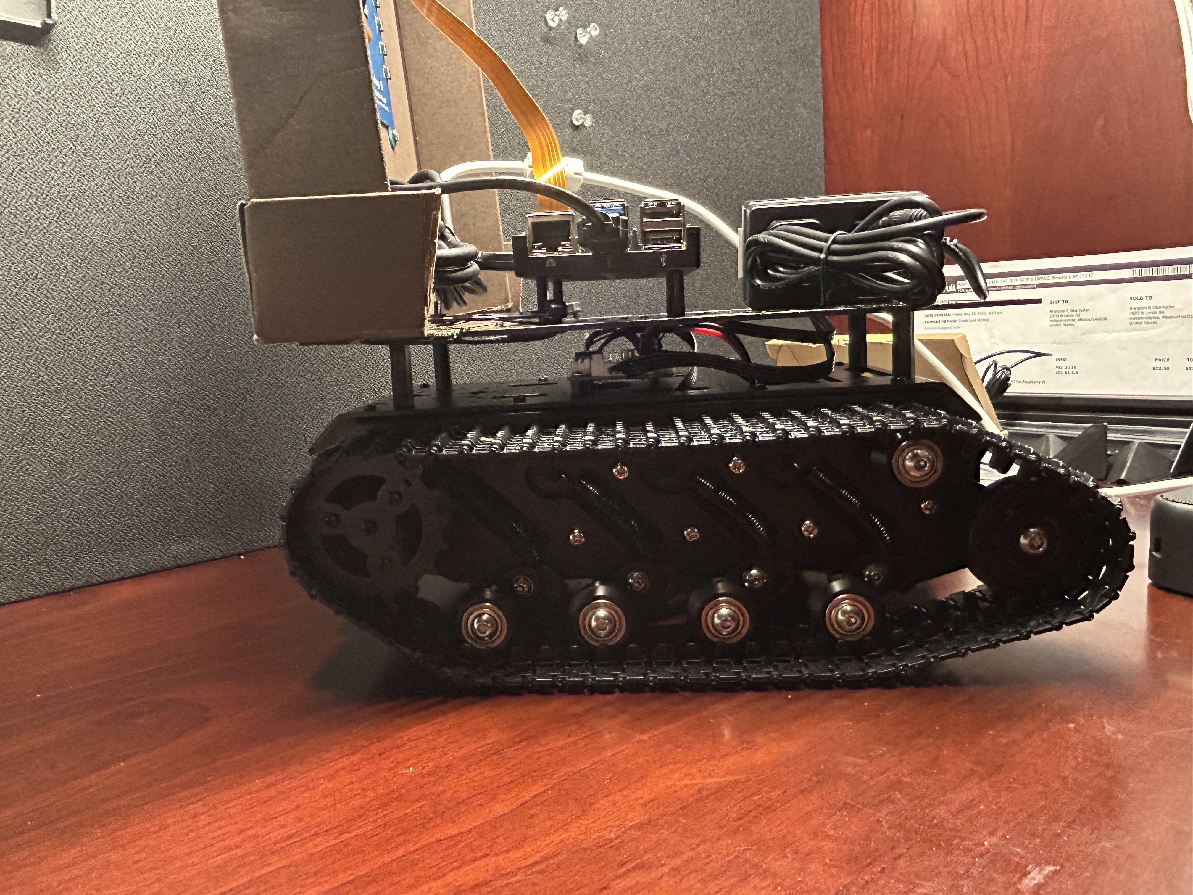 Side profile of tank-track robot with cardboard head